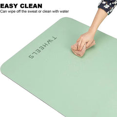 Hand wischt mit einem Tuch Wasser von einer grünen, leicht zu reinigenden TWheels Yogamatte.