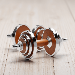 Elegantes TWHEELS Hantelset in Holzoptik auf Walnussholz-Ständer.