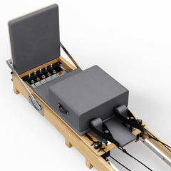 Graue Polster-Box und Federleiste des TWHEELS Pilates Reformer aus Ahornholz