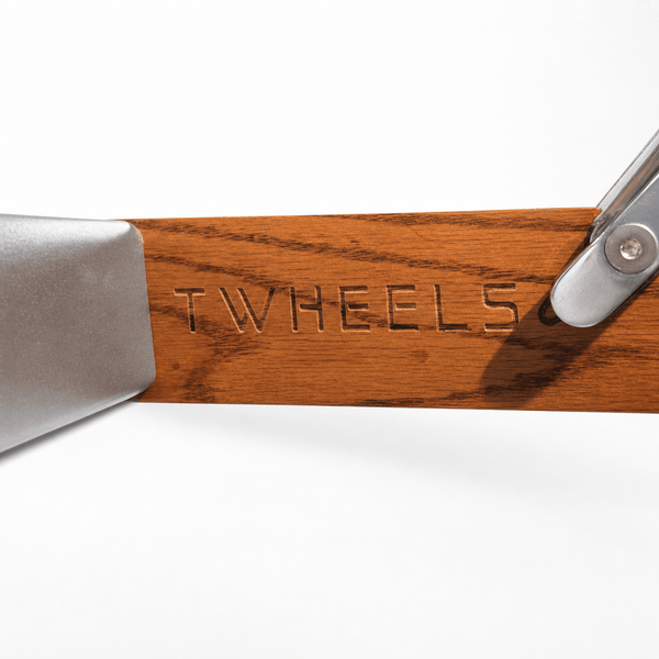 Detail der eingravierten TWHEELS Wortmarke im Roteichenrahmen der Hantelbank