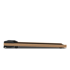 Flaches Walkingpad-Laufband aus hellem Holz mit schwarzem Bedienfeld und Rollen, Seitenansicht.